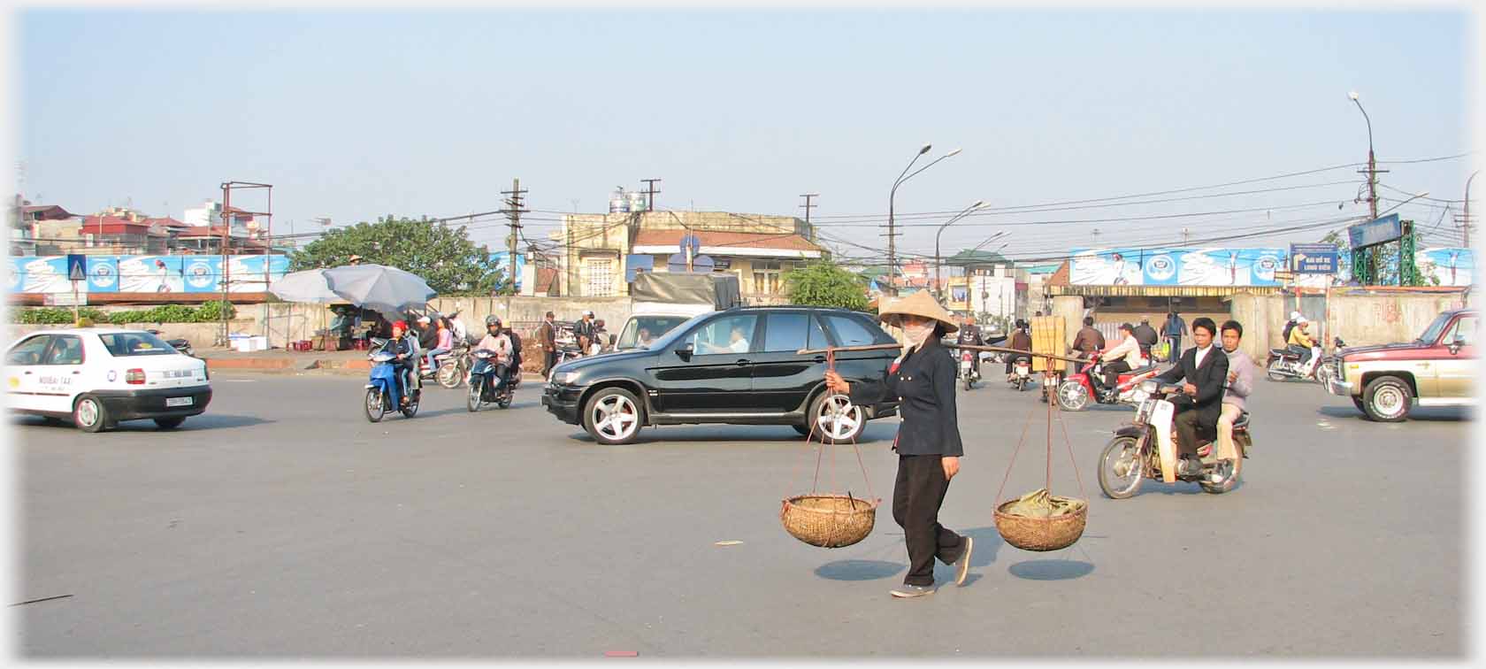 Woman walking across large road intersection.