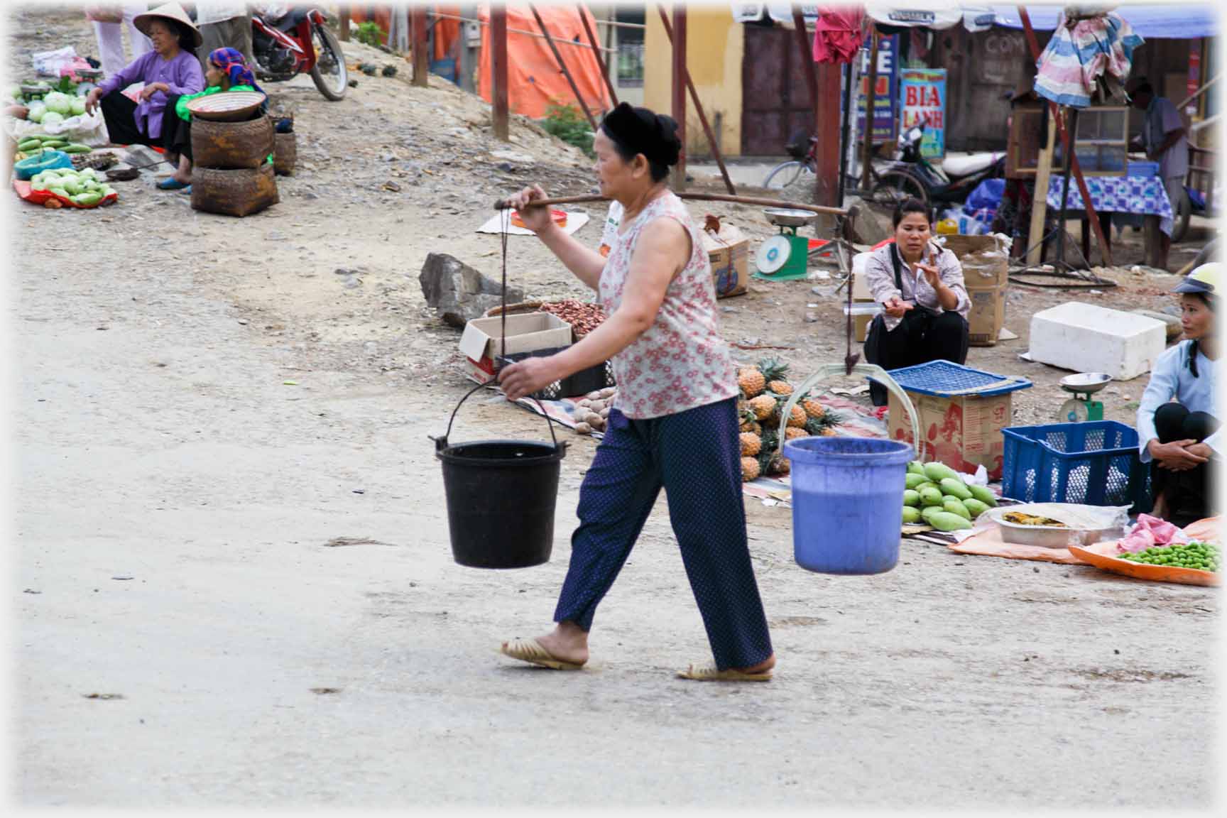 Woman with buckets on pannier.