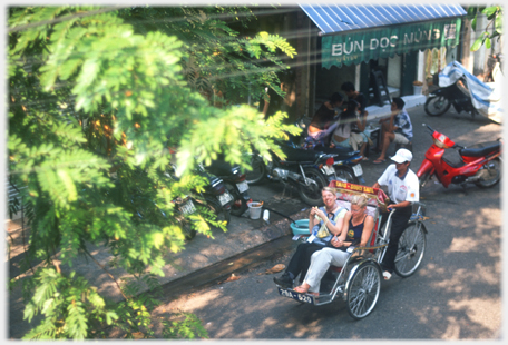 Two women in a rickshaw one looking up at the photographer.