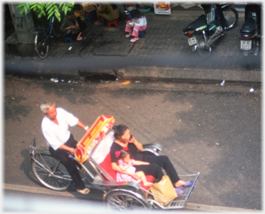 Woman with child in rickshaw, seen from above.