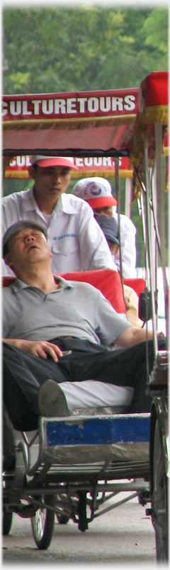 Man head back sleeping in rickshaw.