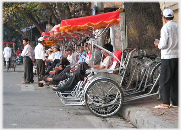 End on view of line of parked rickshaws.