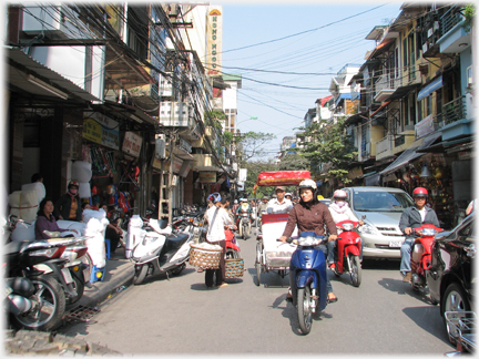 Street scene with rickshaw in amongst traffic.