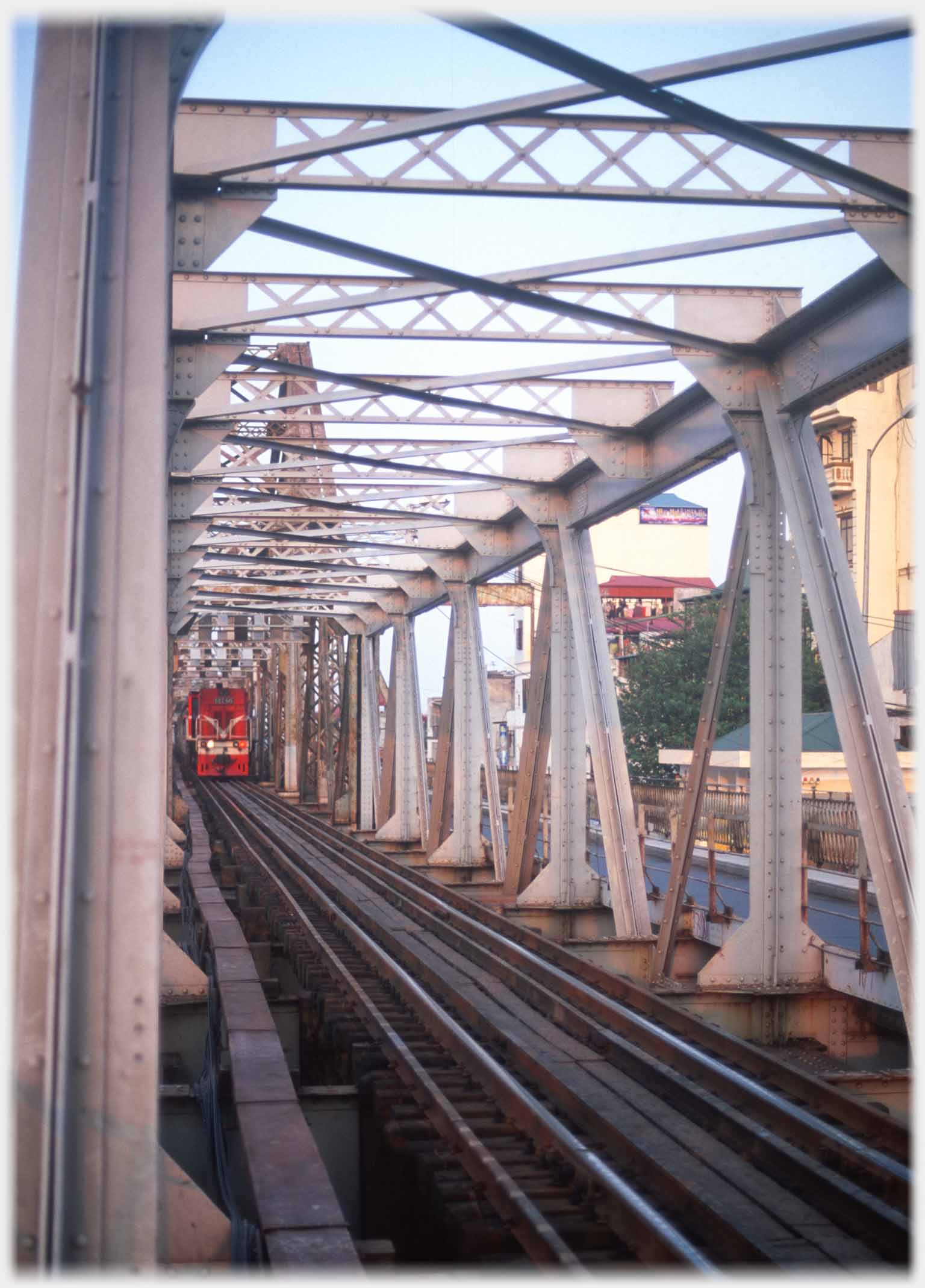 Rails encased in girders with train approaching.