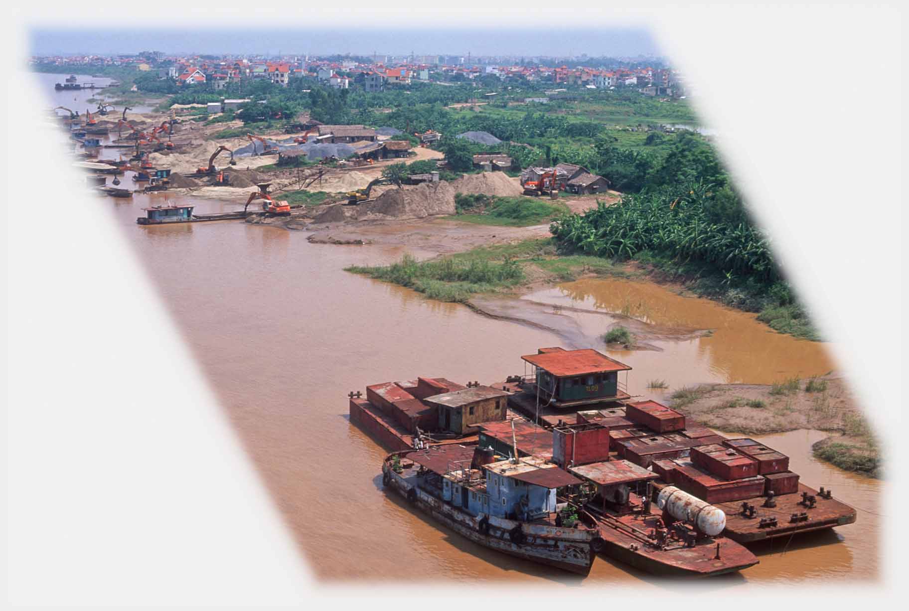 Group of barges laden with rusting iron coloured materials.