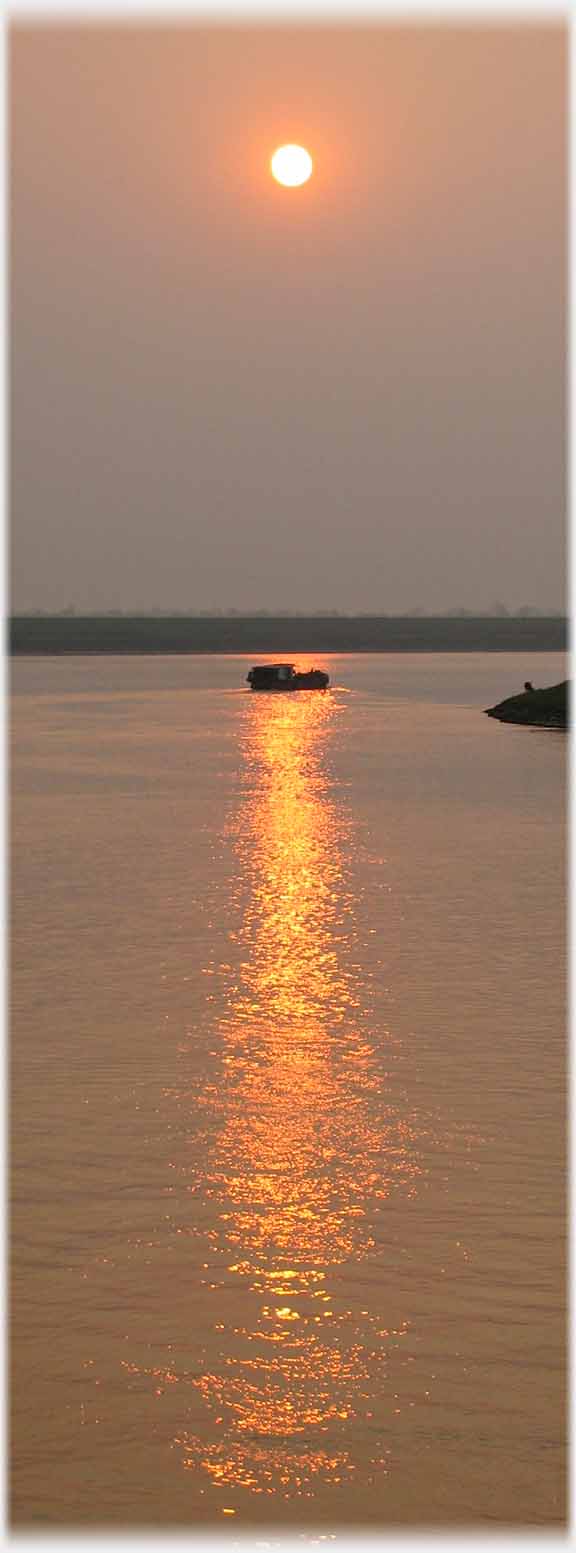 Boat on column of reflected sun.