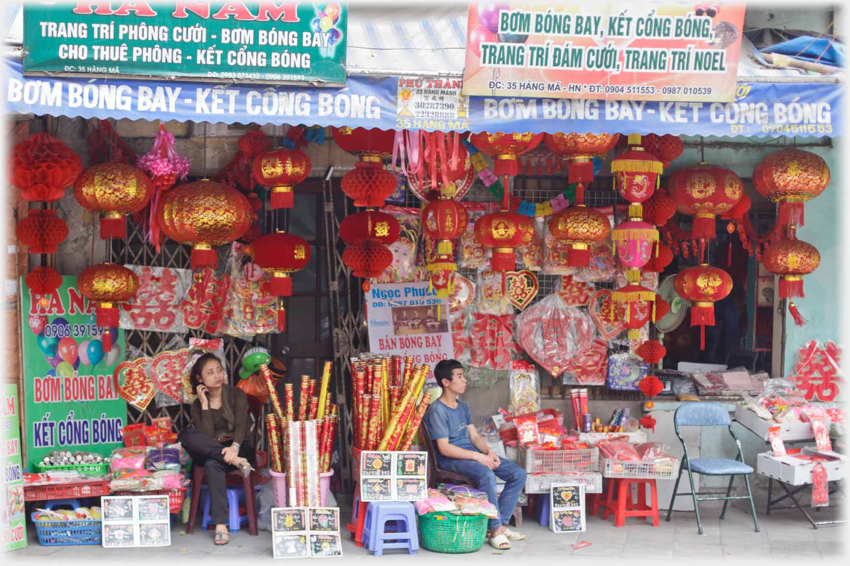 Shop selling decorations, assistants sitting outside.