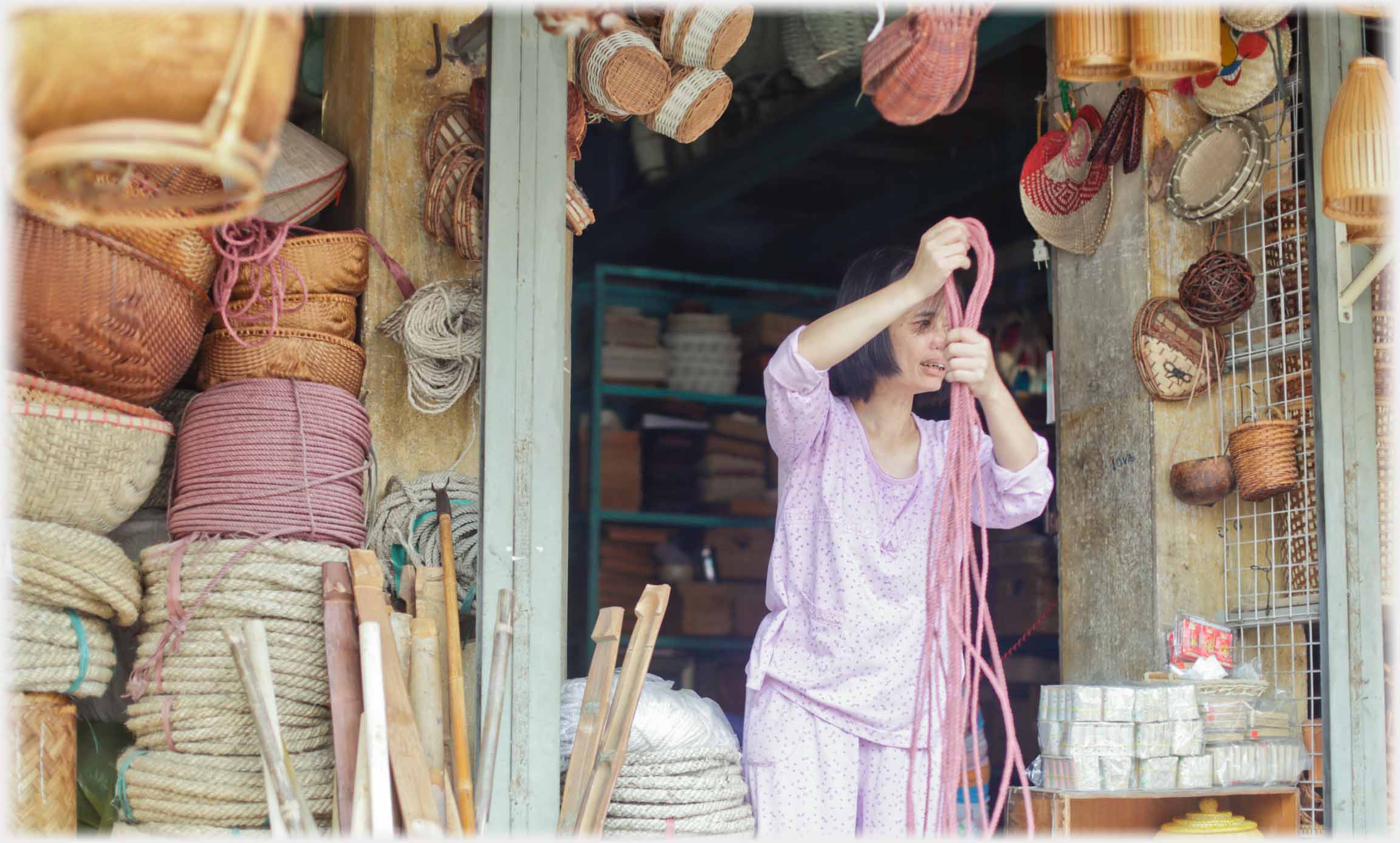 Woman handling rope surrounded by ropes and baskets.