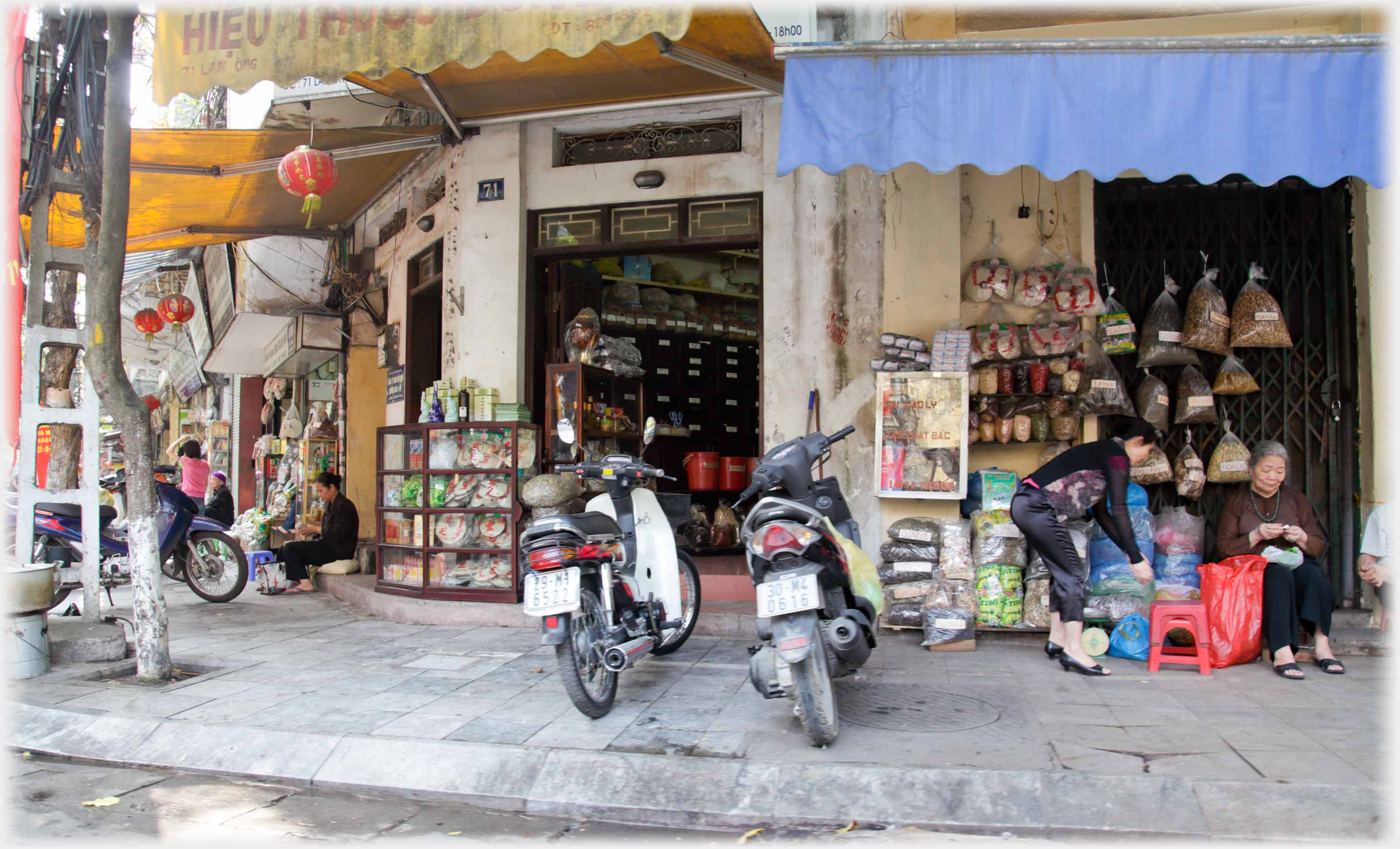 Street corner of shops, motorbikes parked.