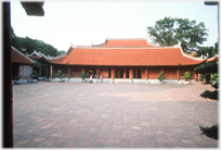 Long single story building with tiled roof.