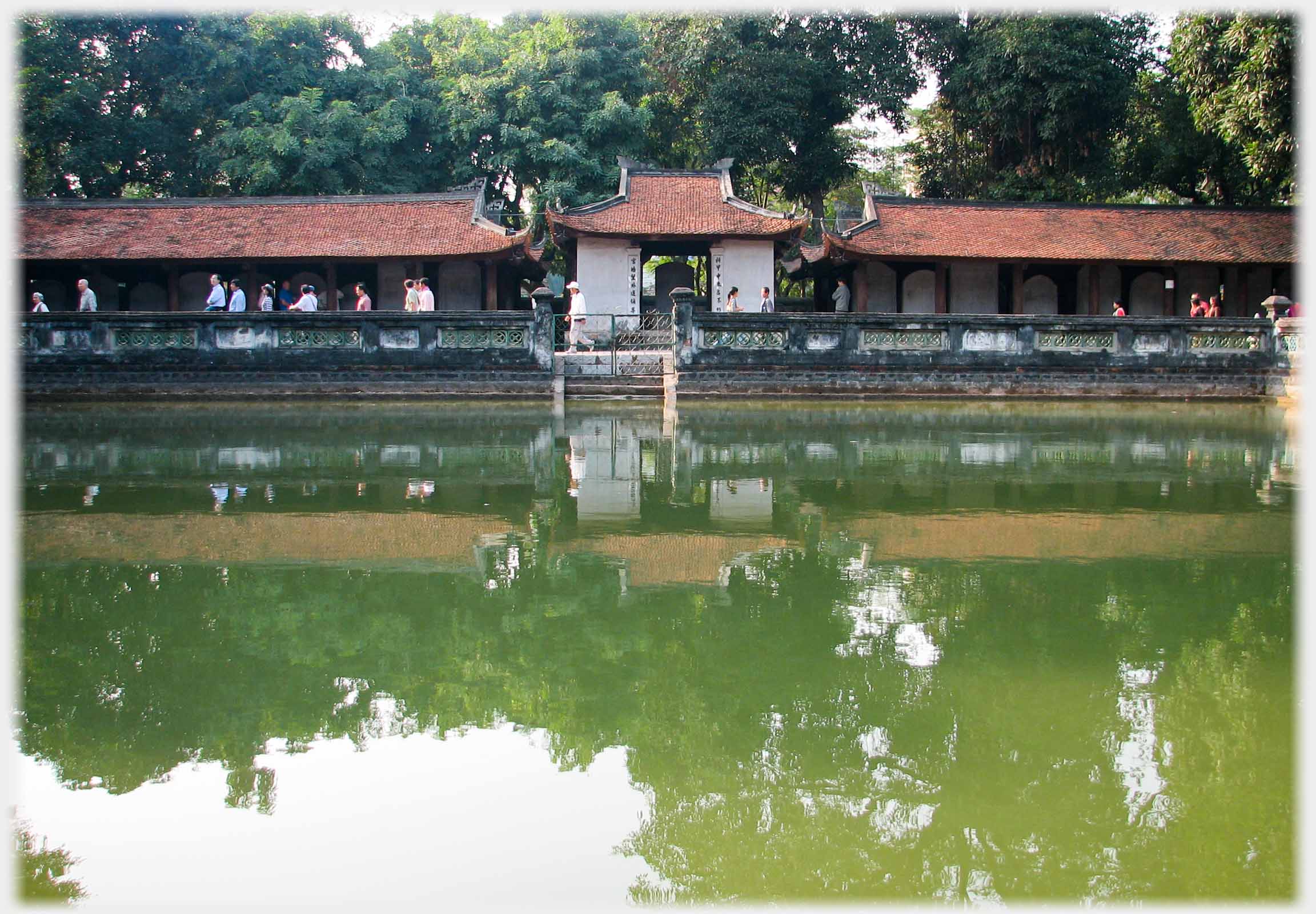 Lake with balustrade and line of buildings.