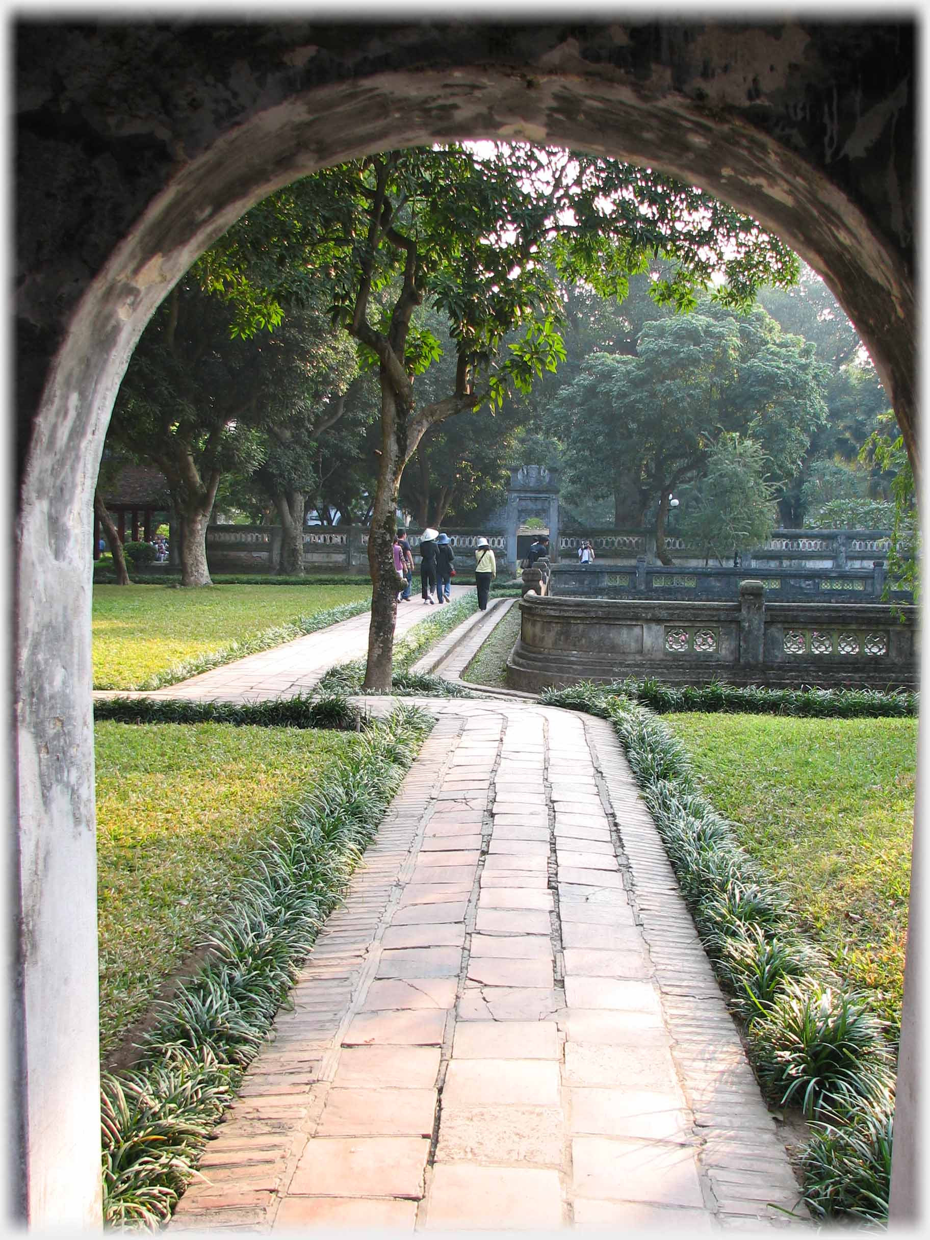 View through arch of pathway and grass.