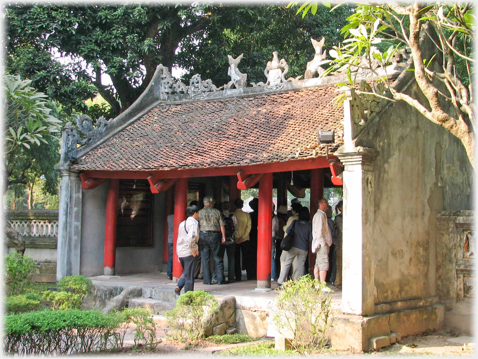 Small vermillion pillard pavilion with elaborate roof ridge carvings.