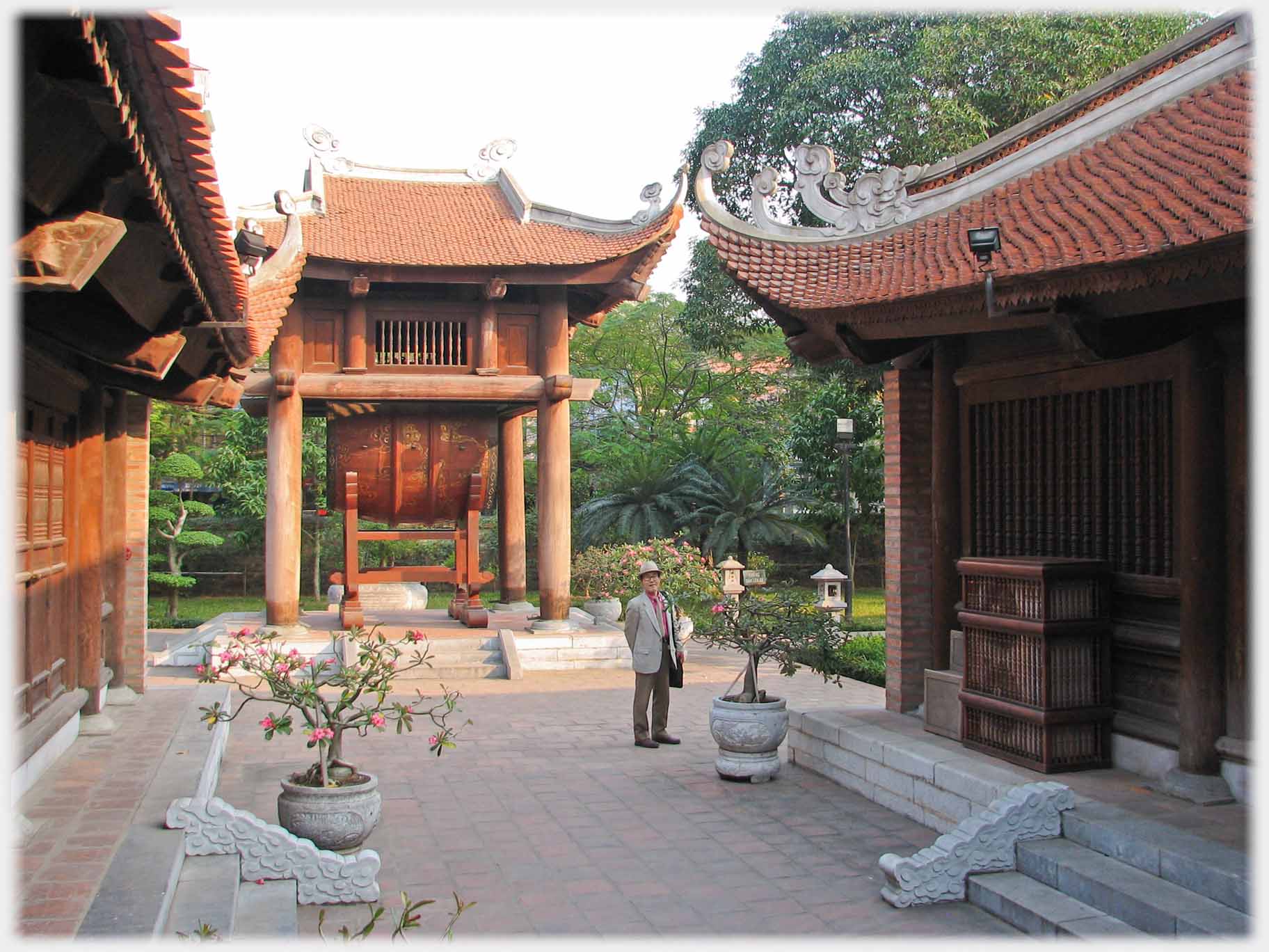 House with huge drum between two lines of buildings.