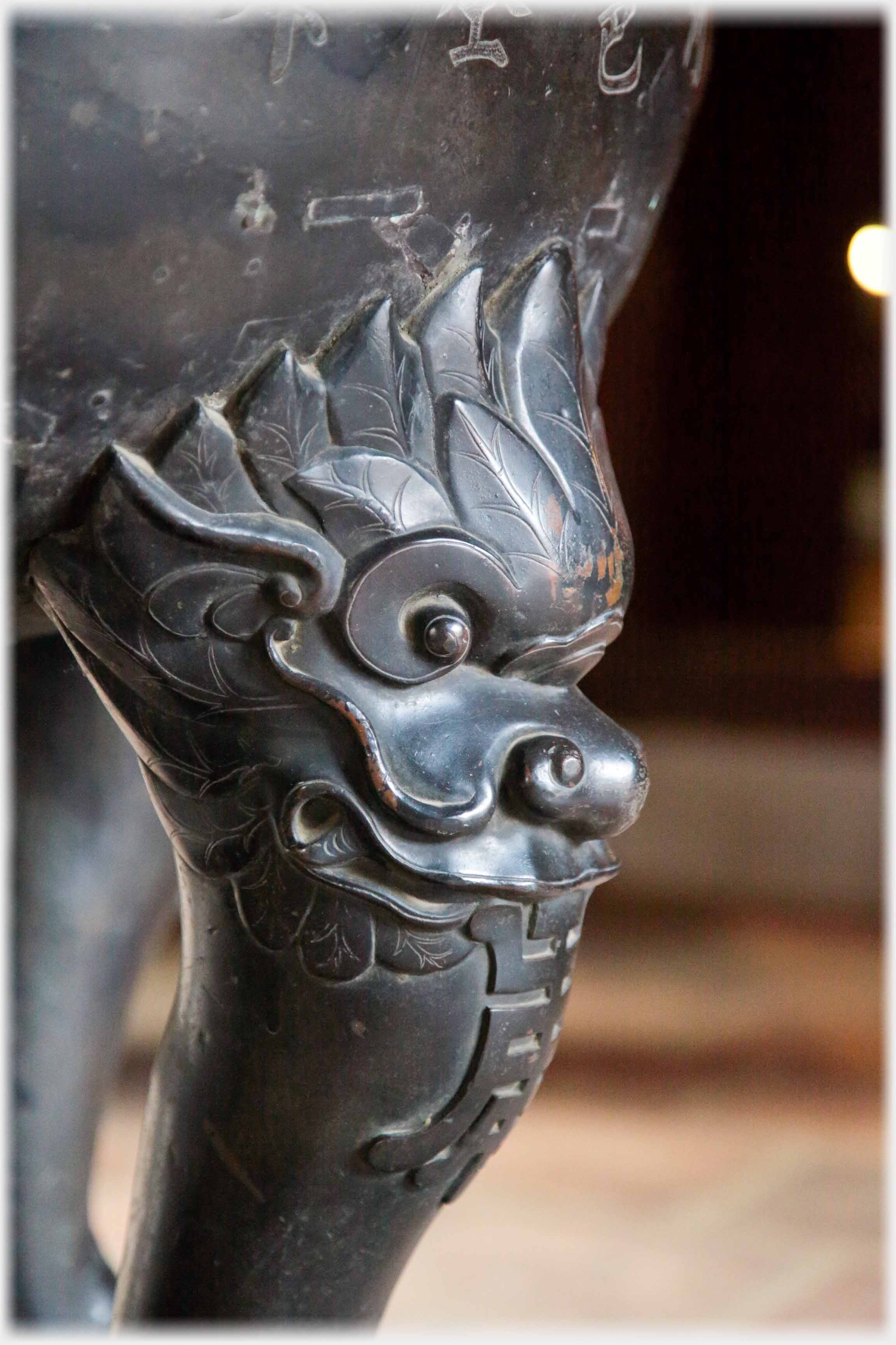 Close up of top of urn leg showing creature's face.