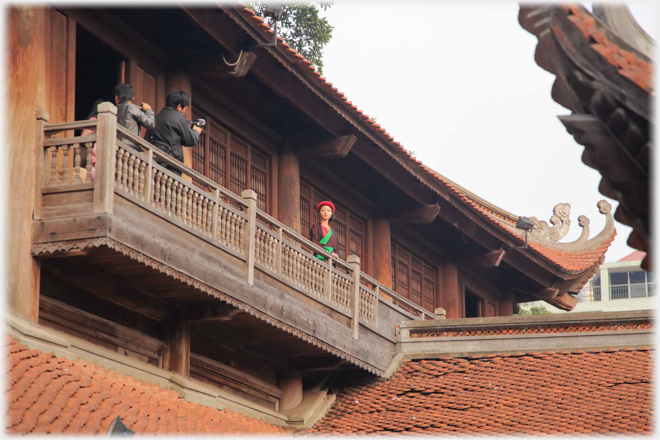 Balcony on two story building with photographer and woman.