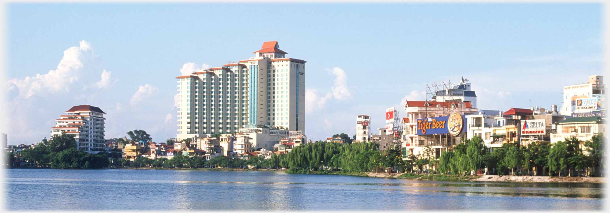 Same large building in context of other buildings by the lake.