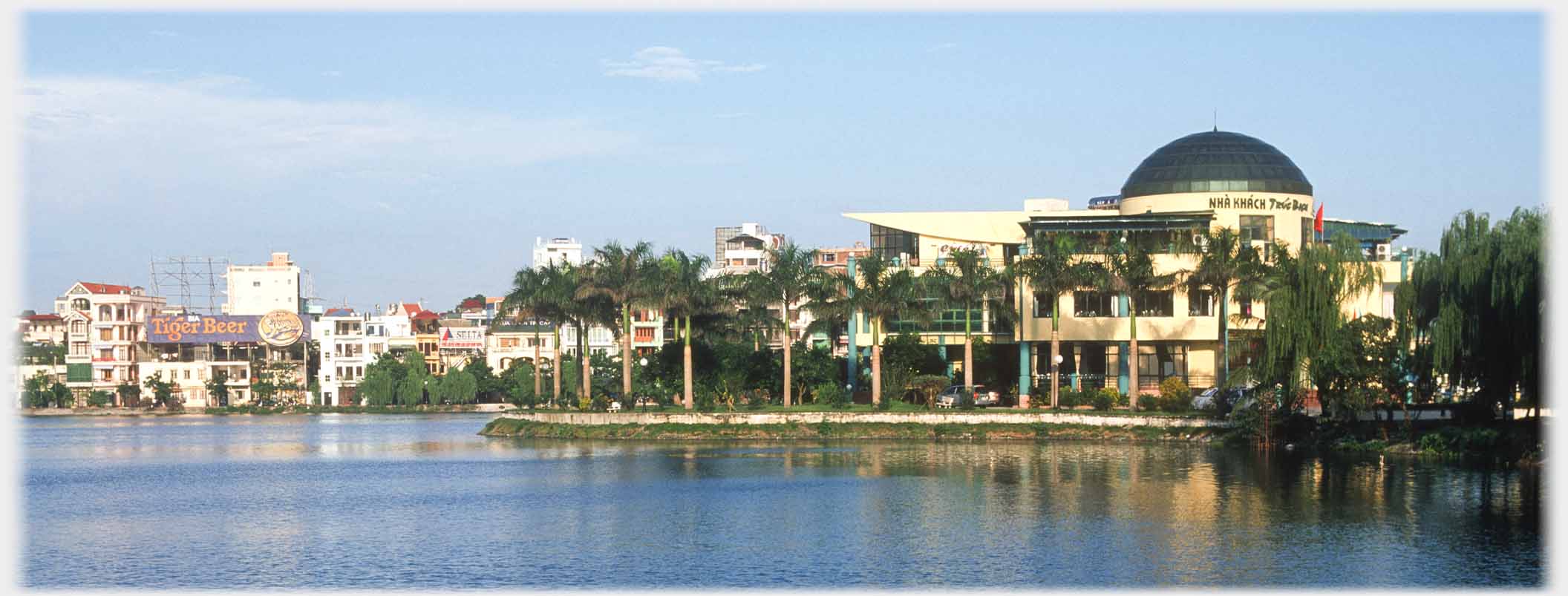 Large domed three story and peaked roof restaurant with trees around it.