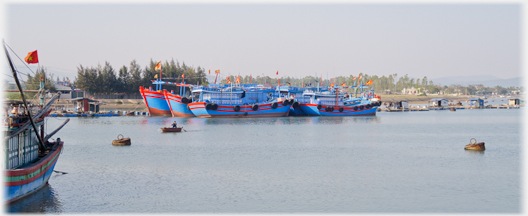 Large ocean going boats in blue and red across the river.