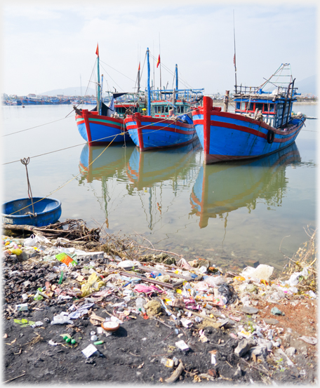 Same picture as above with coracle, but with the bank covered in litter in view.