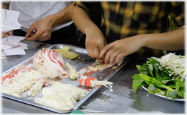 Rolling mushrooms into ham.