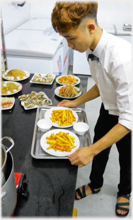 Carrying a tray with plates of chips.