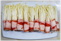 Thread mushrooms wrapped in ham.