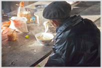 Man eating pho with chopsticks.