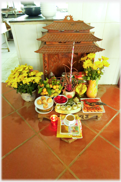 Altar on floor with flowers and other offerings.