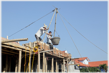 Concrete in bucket being brought to upper floor.