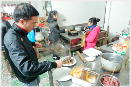 Food being put on plates and cooking in the background.