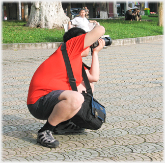 Man crouching taking photograph