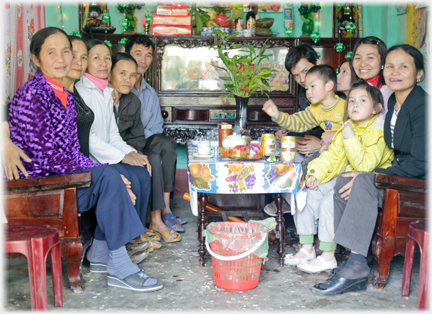 Families crowded onto two benches in front of a display cabinet/altar.