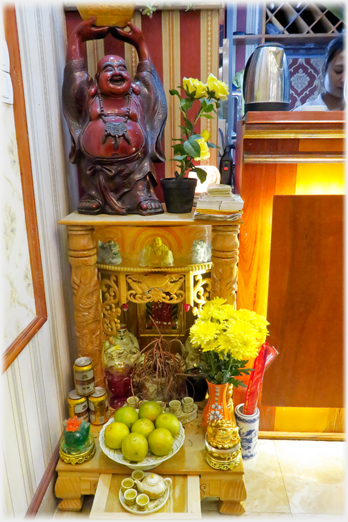 A smart new floor altar with Buddha and offerings of beer, apples aand flowers.