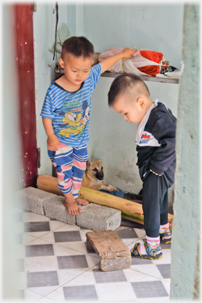 The two infants looking down at a squatting stool.