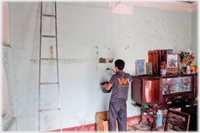 Man filling holes in wall.