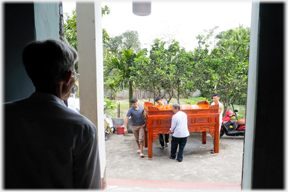 Four men lifting the new altar with Han's father watching.