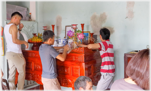 Three men working on arranging the orniments on the new altar.