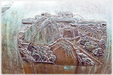 Detail of bronze urn with hills.