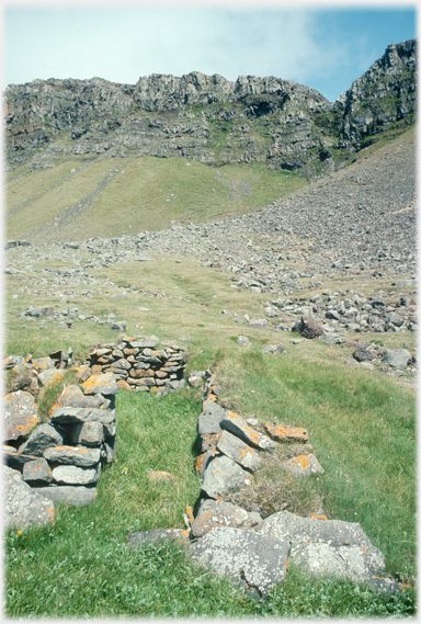 Ruin with cliffs in background.