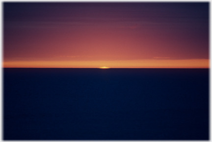 Slither of sun just showing above horizon.