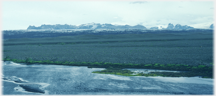 Mountain range beyond ash plane with foreground river.