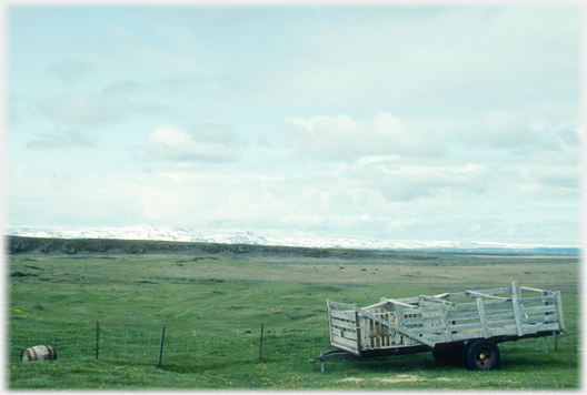 Grass and distant mountains with trailer.