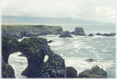 Looking along the coast with an arch in the foreground.