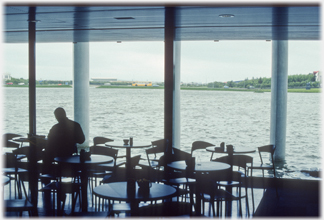 Cafe furniture and windows onto lake.