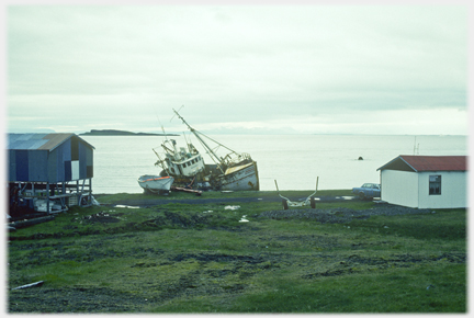 Fishing boat at angle and two buildings.