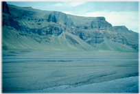 Black sand below hills.