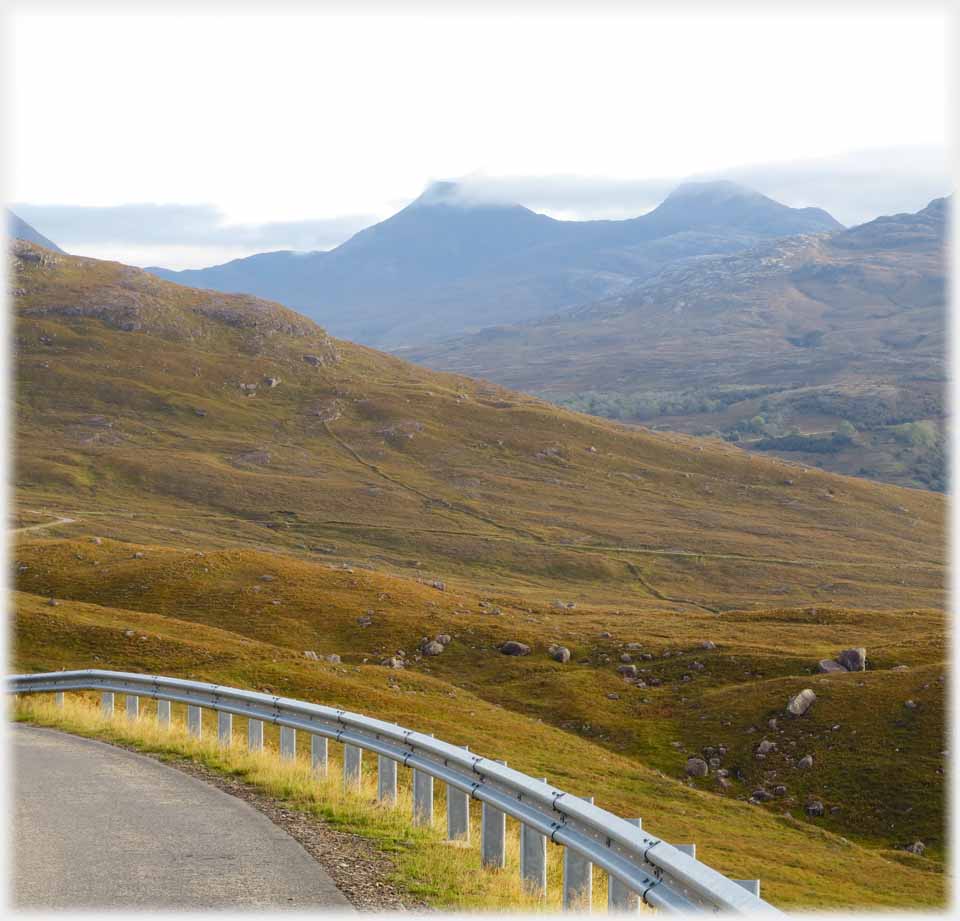 Length of barrier with thread of road beyond.