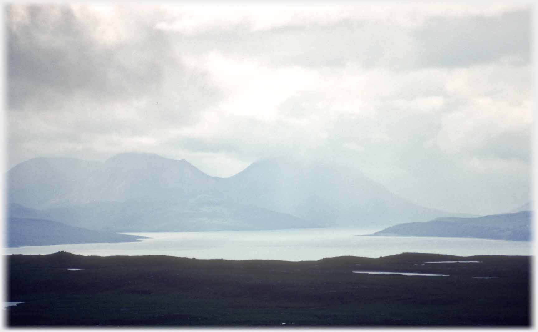 Gloomy foreground with sea hill and cloud.