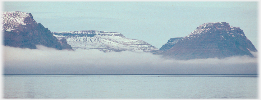 Thick blanket of mist under mountains on the sea.